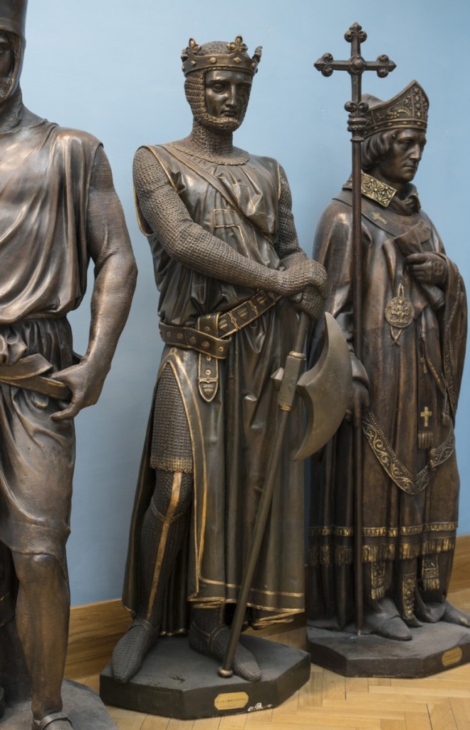 "A life-size figure of Saher de Quincy, Earl of Winchester, with crown and axe. This is a prototype for the equivalent bronze statue in the House of Lords", via ArtUK website.